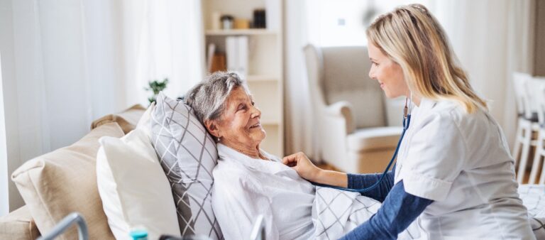 Junge Frau pflegt eine ältere Dame